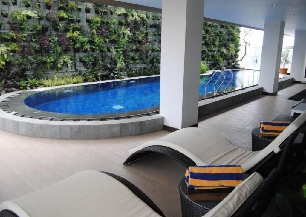 Kolam renang dBest Hotel Bandung dengan dinding hijau